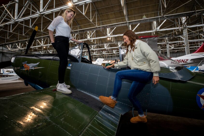 Rachel Coull steps inside a vintage fighter plane watched by flight instructor Kerrin Dutton at the Scottish Aero Club event.