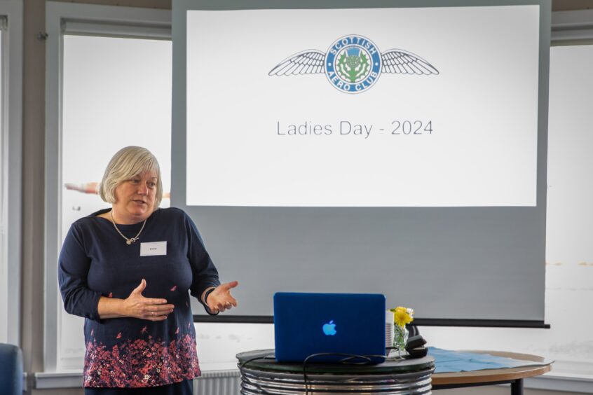 Elaine Whitehead speaking in front of a Ladies Day 2024 slide