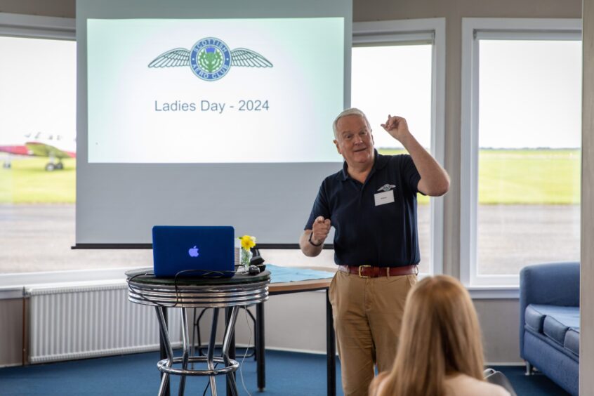 William Scott speaking to women in Scottish Aero Club lounge at Perth airport