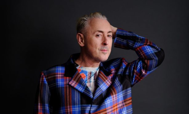 Alan Cumming in tartan suit