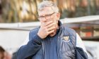 Craig Levein holds his face while wearing a St Johnstone FC jacket