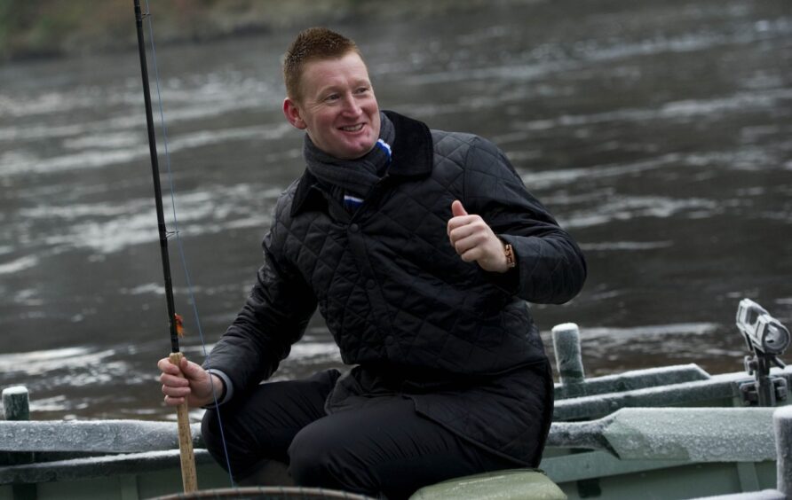 Thumbs up from then St Johnstone manager Steve Lomas as he braves the elements to cast the first line of the 2012 fishing season on the River Tay.