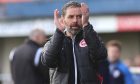 Larne FC boss Tiernan Lynch applauds the fans