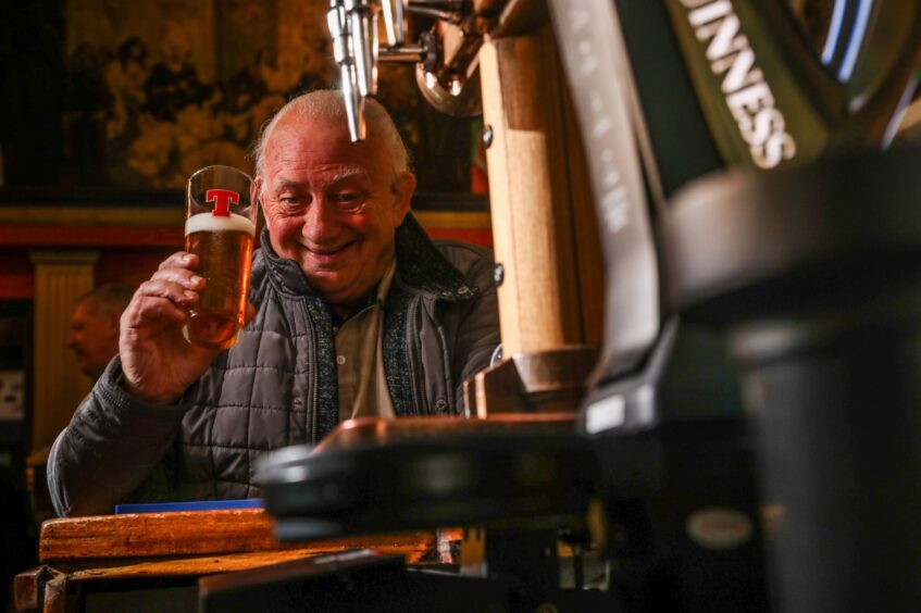 Russell Gemine with a pint of beer in Pillars Bar.