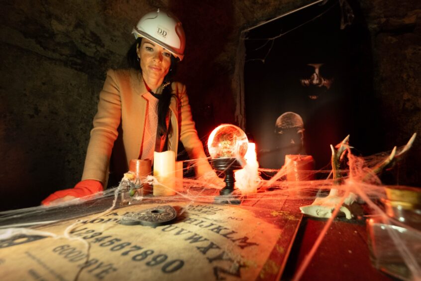 Gayle checks out a ouija board within Dundee vaults. Image: Paul Reid. 