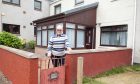 Brechin pensioner Ian Stewart at his garden gate where he spoke to the media hours before Storm Babet's full force hit. Image: Paul Reid