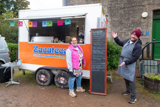 David and Hazel Lowe outside their Mexican food truck at Crombie Country Park, pointing to their menu.