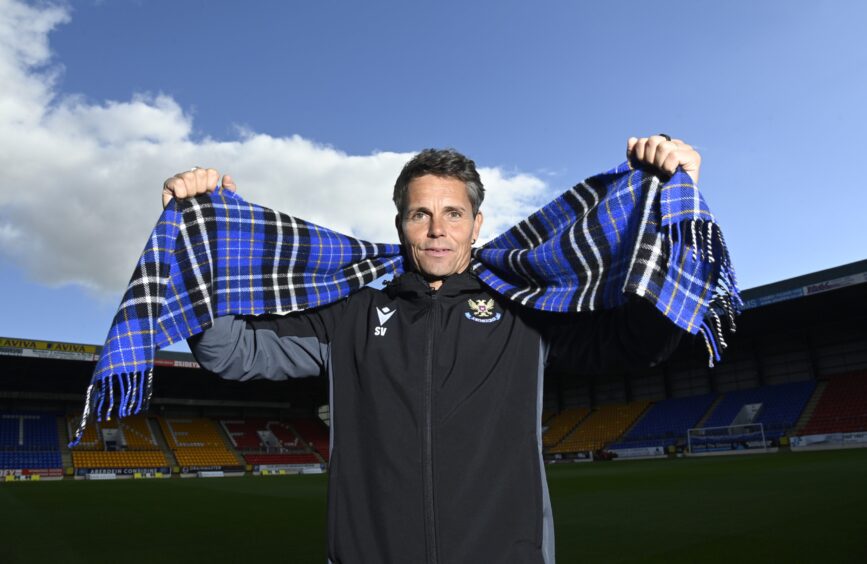 St Johnstone boss Simo Valakari holds up a club scarf at McDiarmid Park