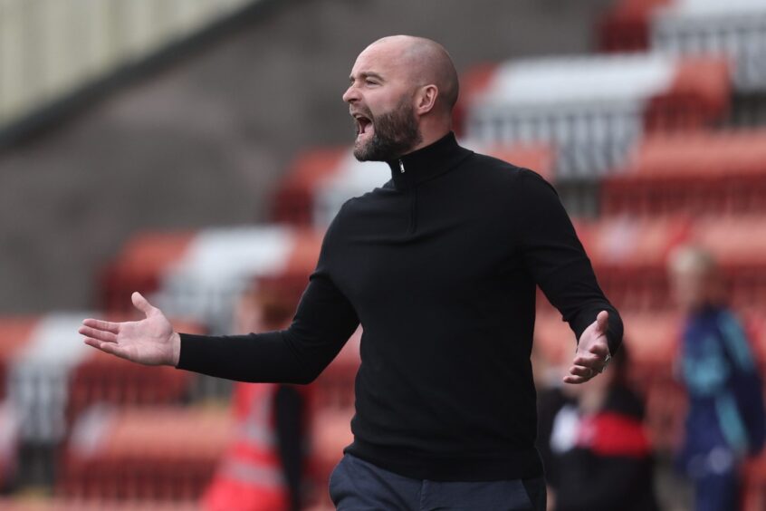 Dunfermline Athletic F.C. manager James McPake roars instructions from the side of the pitch.