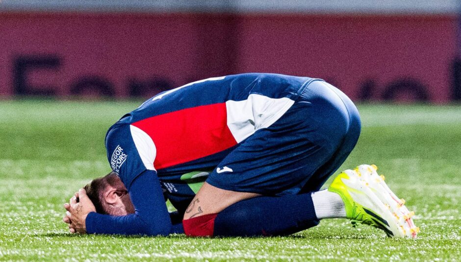 Josh Mullin lies with his head in his hands after sustaining an injury.