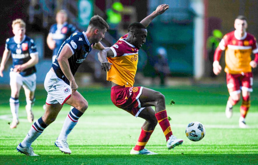 Ryan Astley gets to grips with former Dundee star Zach Robinson. Image: Sammy Turner/SNS