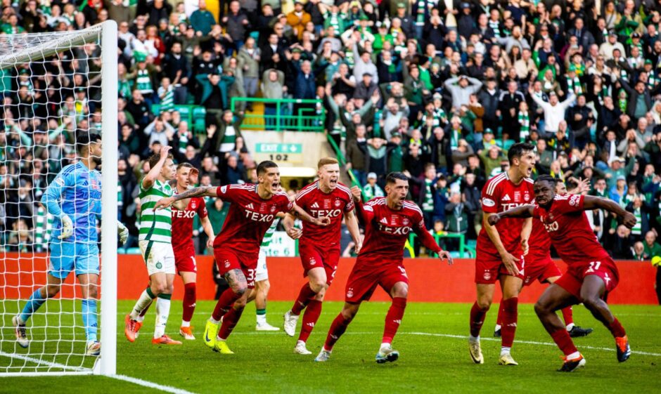 Aberdeen players celebrate after an excellent result at Celtic Park.