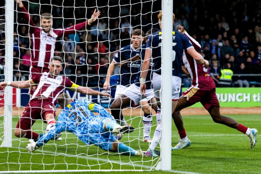 Nicky Clark scores from close range, as the Dundee goalkeeper dives for the ball in a crowded box