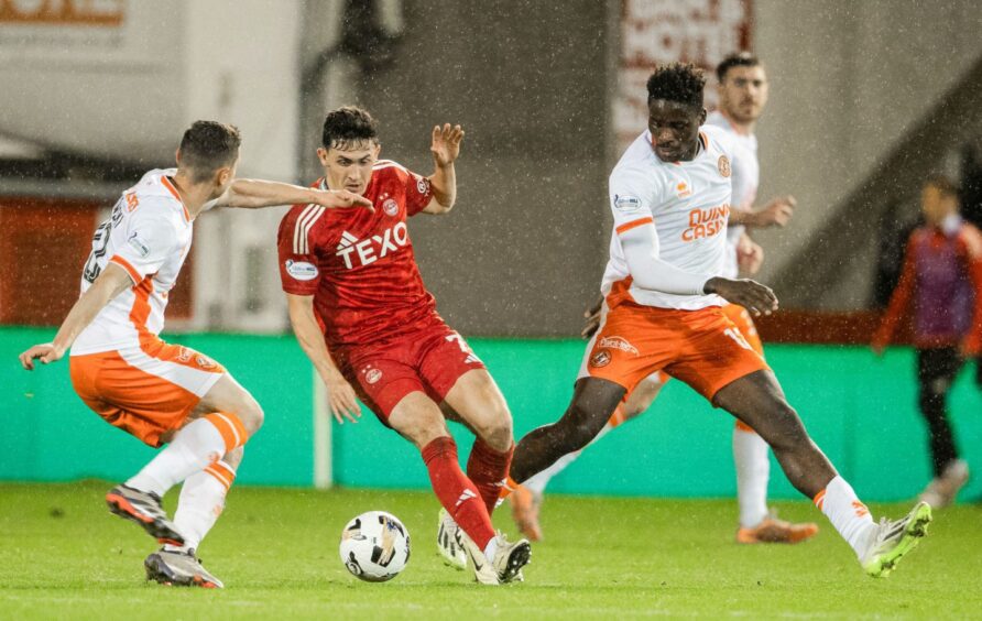 Richard Odada, right, gets stuck into the action against Aberdeen