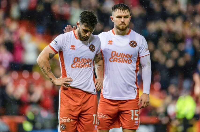 Will Ferry, left, cuts a dejected figure following his part in the Dons' winner