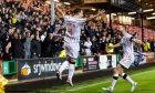 A celebrating Kyle Benedictus jumps in the air and is greeted by Craig Clay after putting Dunfermline 2-0 ahead against Livingston.