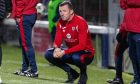 Departed Raith Rovers manager Neill Collins crouches down at the side of the pitch.