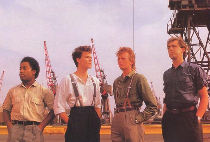 Big Country band members pose with cranes in the background.