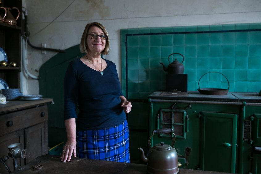 Tour guide Anne Monaghan in the kitchen beside the old oven.