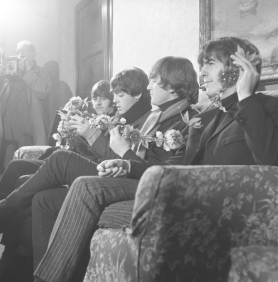 The band backstage posing with thistles for a photograph. 