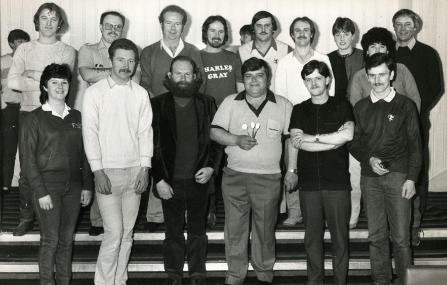 Jocky Wilson, darts in hand, poses for a picture at the charity event. 