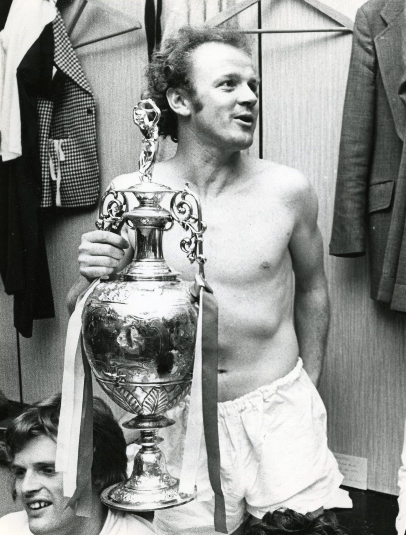 a topless Bremner in the dressing room with the league title trophy he won with Leeds in 1974. 