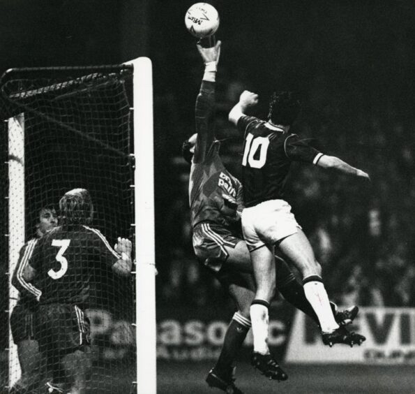 Bruce Grobbelaar in action for Liverpool against Dundee in 1987, punching the ball clear in the six-yard box