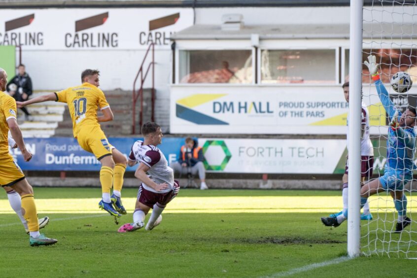 Matty Todd volleys in the winning goal for Dunfermline despite the best efforts of the Kelty Hearts defence.