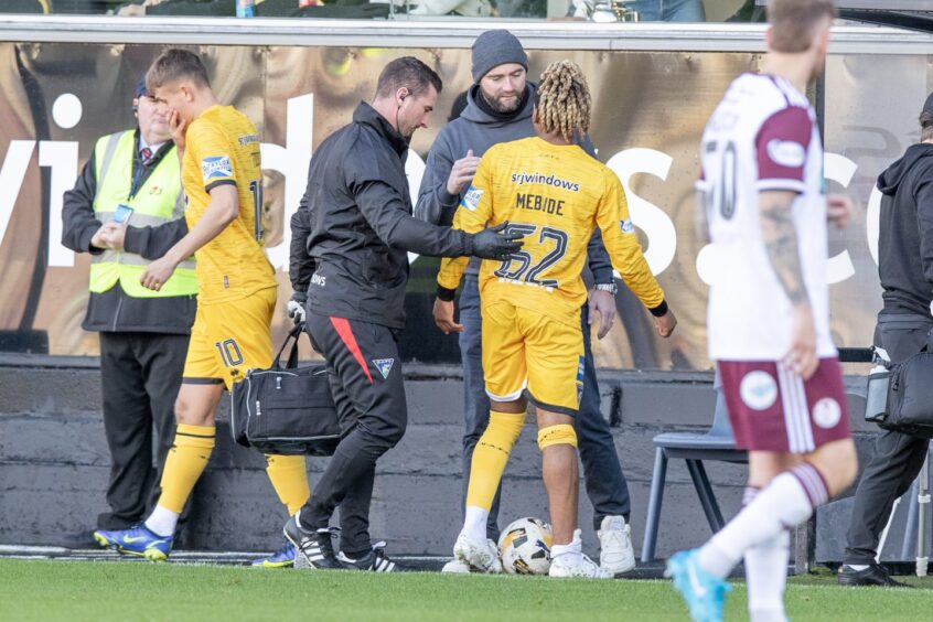 Dapo Mebude limps off and is comforted by Dunfermline Manager James McPake.