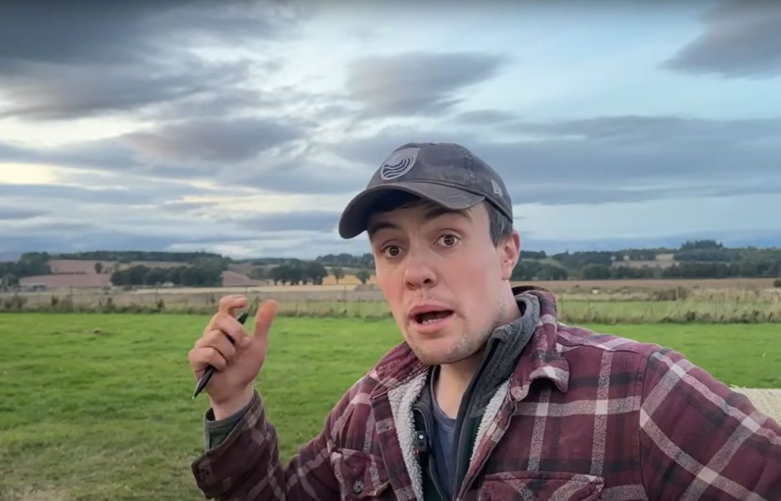 Crawford Niven pointing to farmland behind him