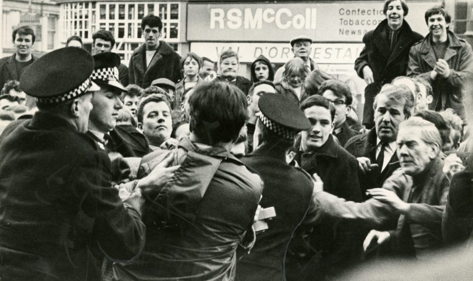 Police officers struggle to control protestors at a demonstration in Dundee. 