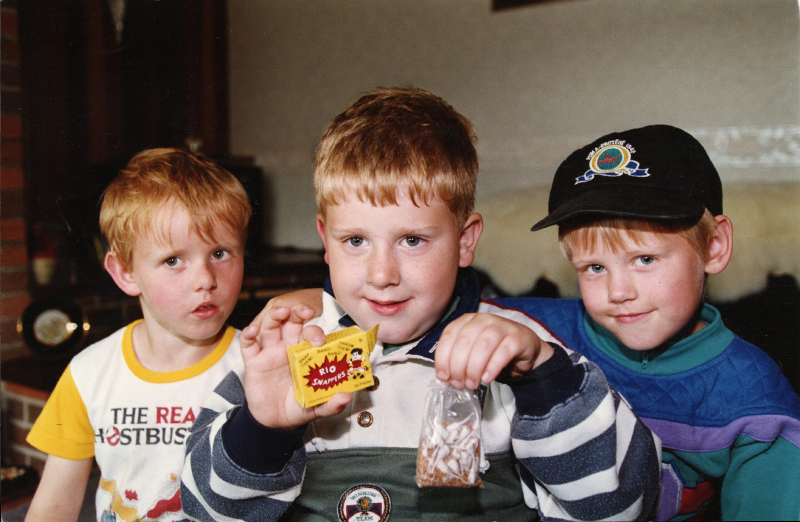 Philip Clark, Christopher Devine and Barry Clark sitting on a couch and holding the fireworks.