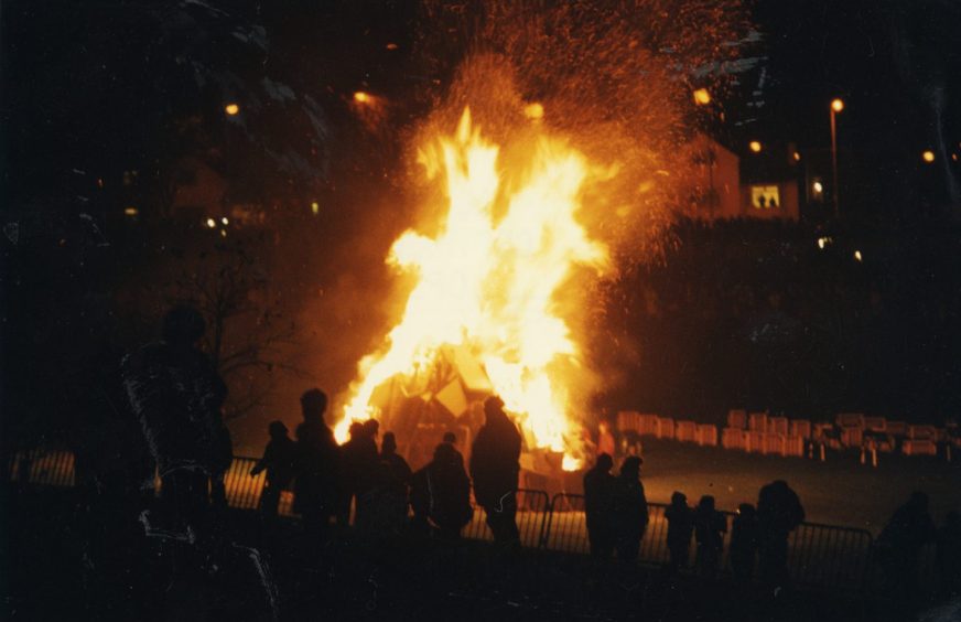 crowds around a bonfire at night at a Dundee event