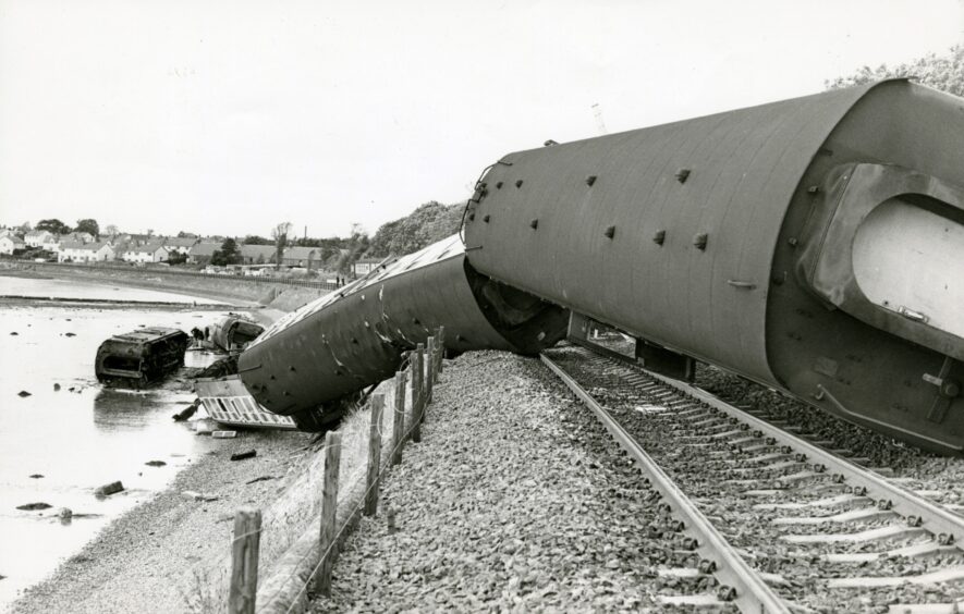 The derailed carriages on their sides on the track and down the embankment.