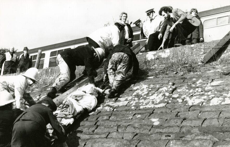 The injured being brought up the embankment of the River Tay. 