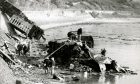 Rescue workers searching for victims in a stricken carriage. Image: DC Thomson.