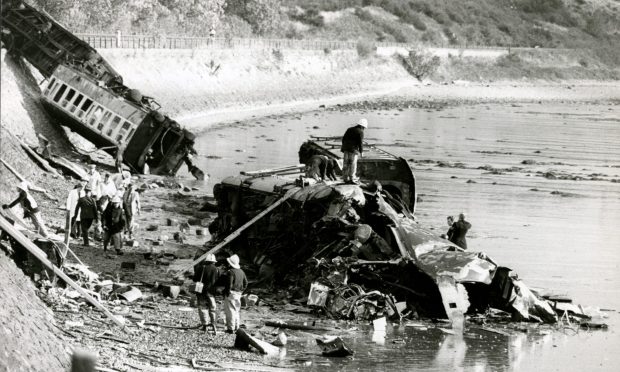 Rescue workers searching for victims in a stricken carriage. Image: DC Thomson.