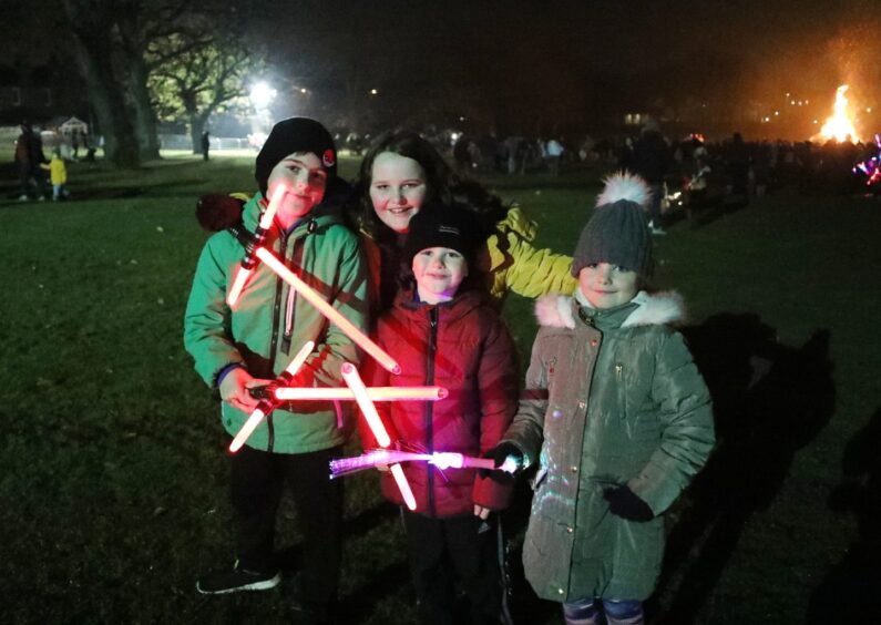 Smiling children with light-up wands pose for a picture at the fireworks event in Baxter Park in Dundee in 2018.