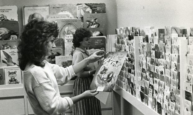 Two women hold up greetings cards while doing a quality check for Valentines in Dundee