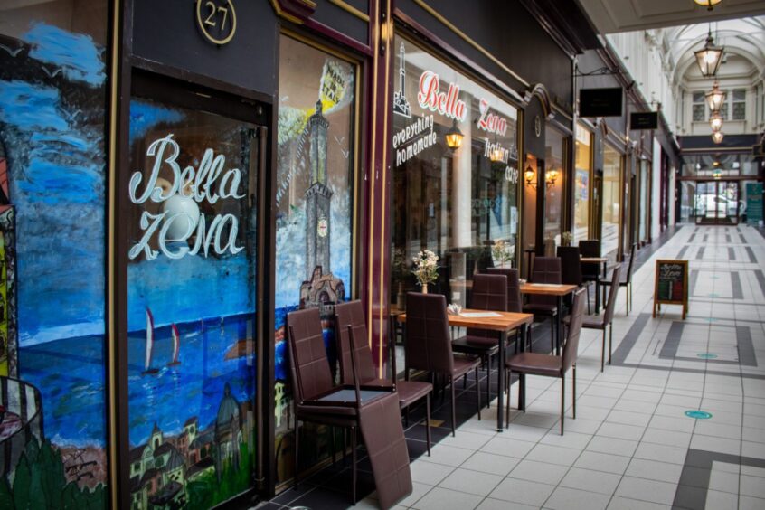 Exterior of Cafe Bella Zena inside Stirling Arcade with chairs and tables outside and the rest of the arcade visible in the background.