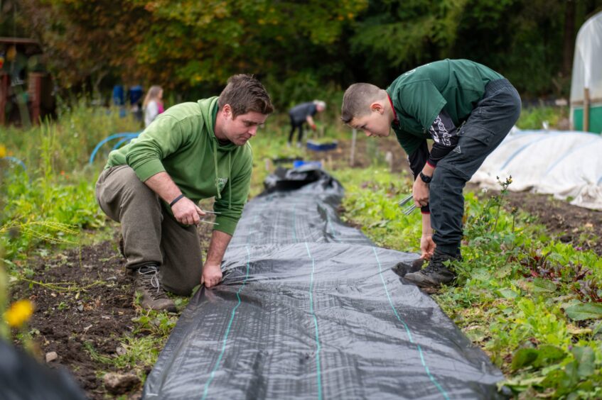 Oscar working with Andy McGovern to put down some weed membrane.