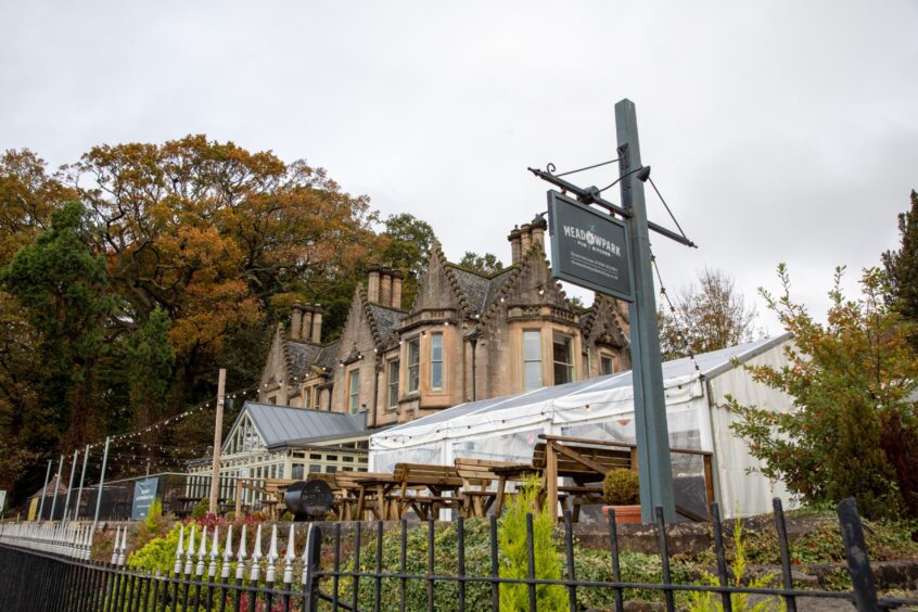 The exterior of the large Meadowpark Hotel with it's classic Scottish architecture of turrets and with a large marquee and gardens outside.