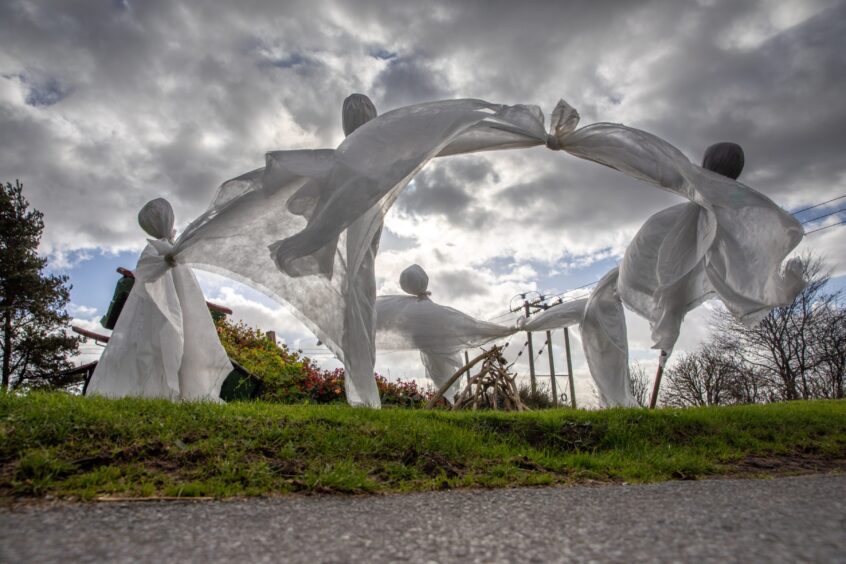 Image shows: ghosts on display in New Gilston, Fife, ghostly figures draped in white sheets are waving in the wind against a stormy sky.