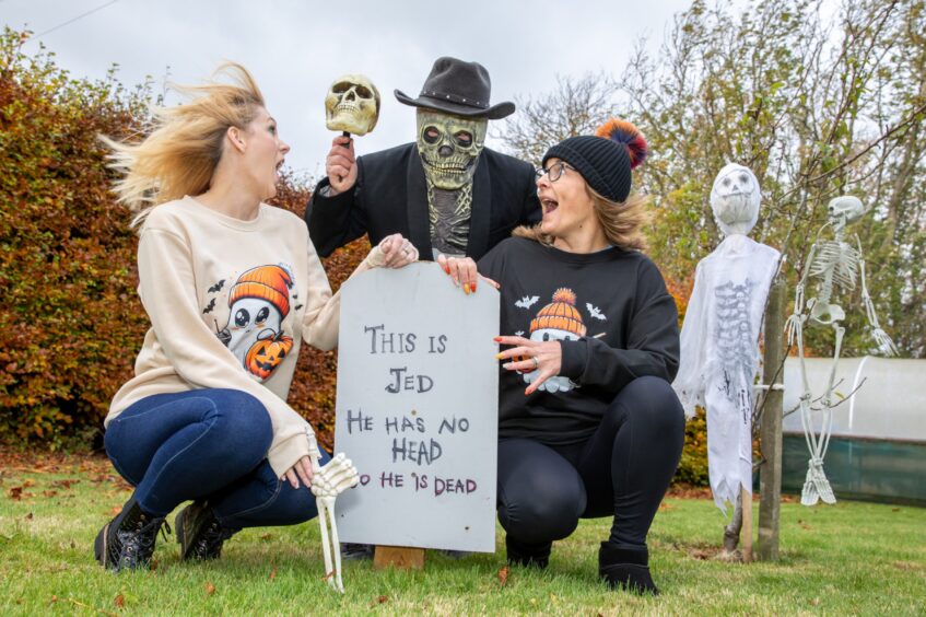 Image shows: Leanne Law and Kim Couper being frightened by a scary Halloween character in the graveyard they created for New Gilston's Halloween celebrations.