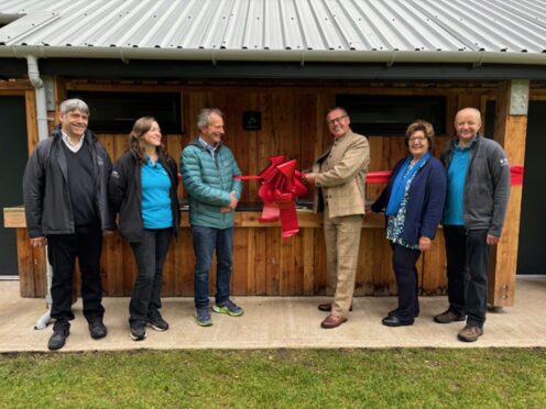 Group of people cutting ribbon in front of visitor centre at Grandtully