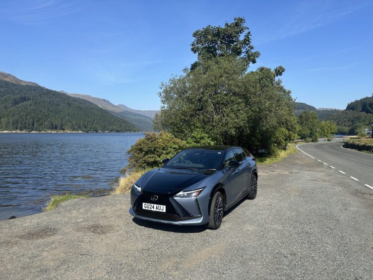 The Lexus RZ seen from the front while parked beside a loch