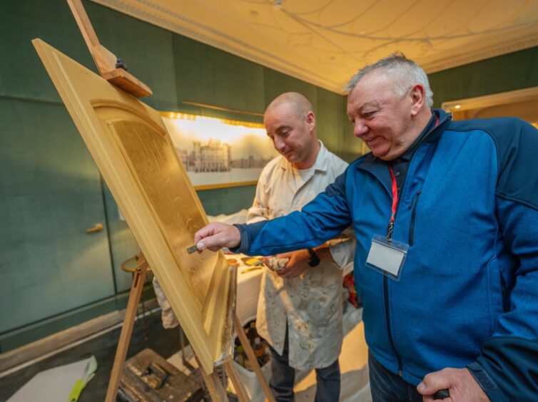 Mark Nevin shows some decorative techniques to a visitor.