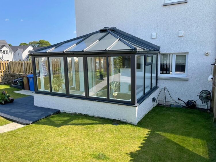 a conservatory with black framed windows