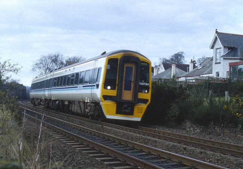 A Class 158 unit passing Barnhill Rock Garden in March 1991. 