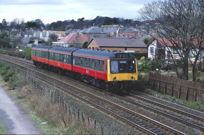 107033 from Strathclyde pulling a local service, with houses in the background